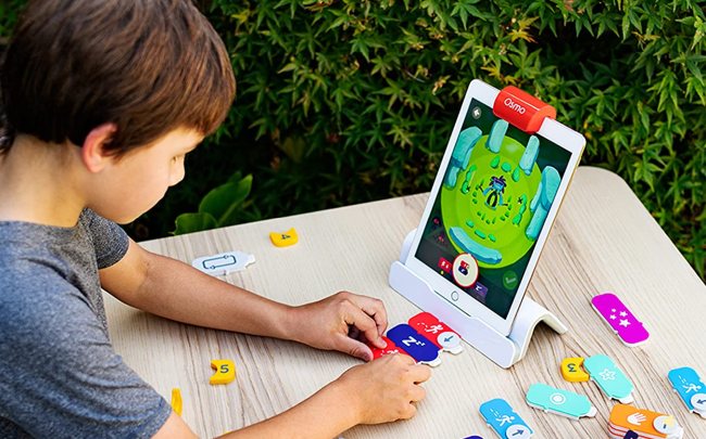 Child playing with a tablet and Osmo coding games for kids