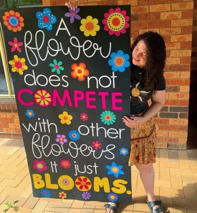 a flower does not compete with other flowers it just blooms. classroom door colorful flowers