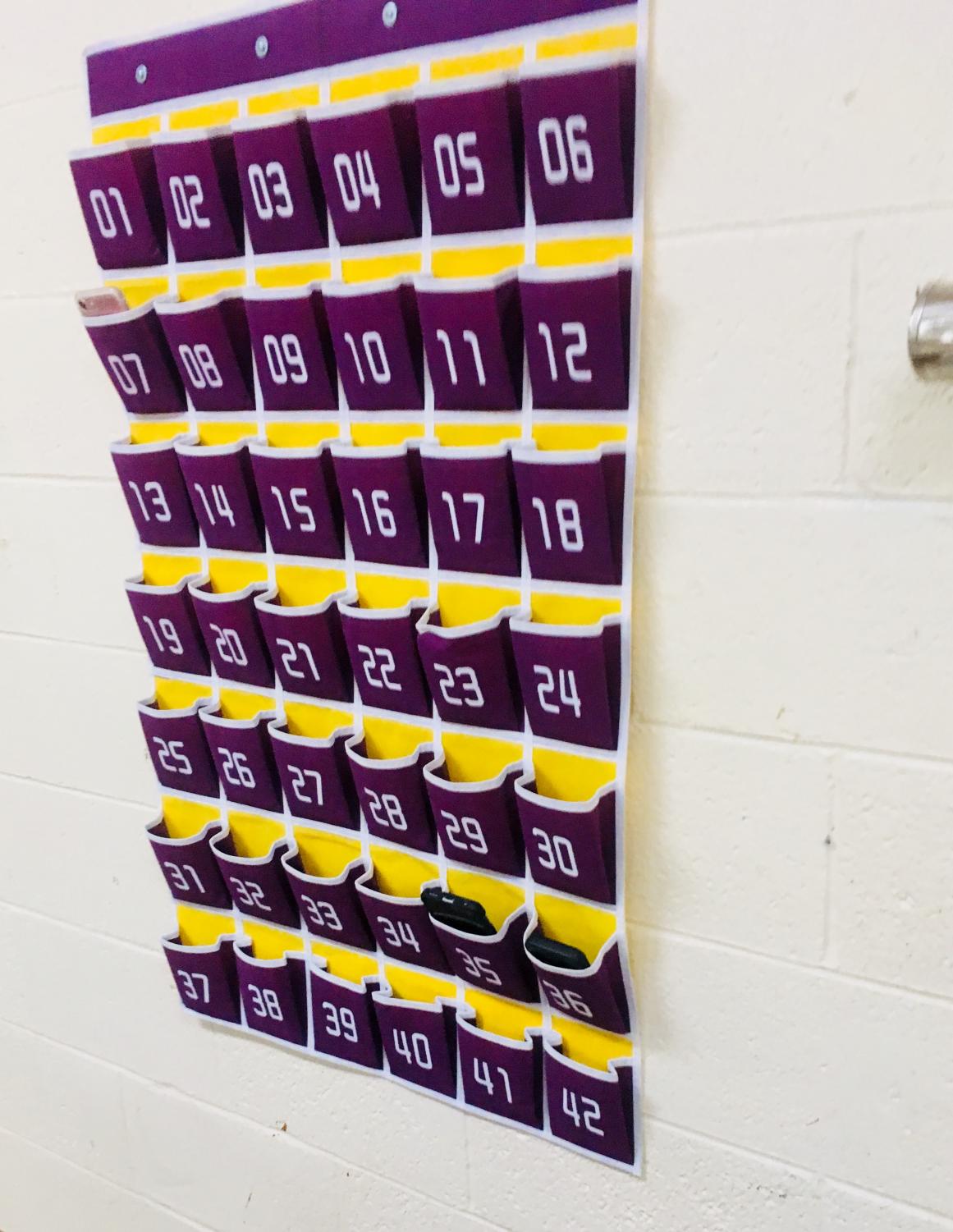 Purple and yellow slots are on a hanging cubby. They are numbered. 