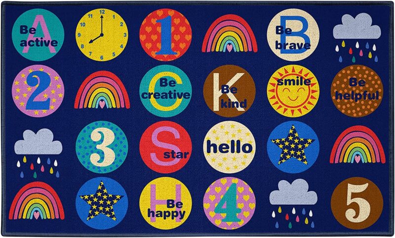 Different circles on a blue rug have different sayings and designs like Be Happy and a rainbow and a clock. This rug is an example of classroom rugs.