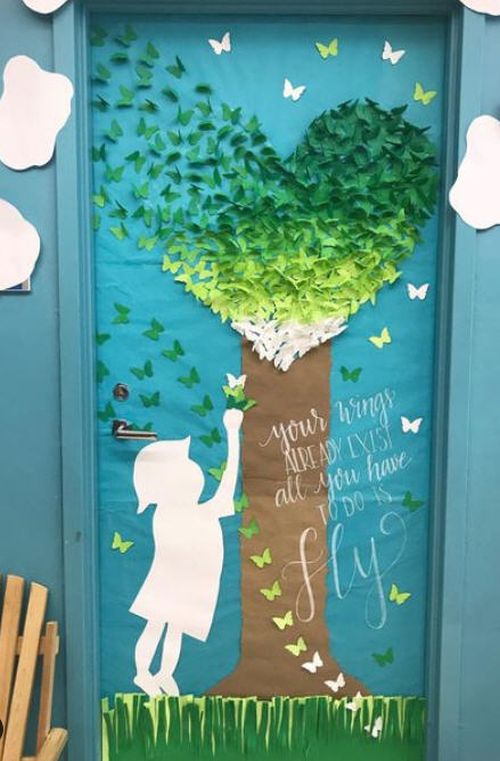 Door decorated with a paper tree made of blue and green butterflies and s child's silhouette. Text reads Your wings already exist. All you have to do is fly.