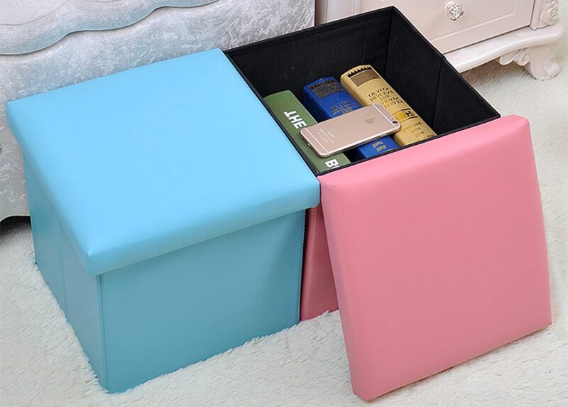 A blue and pink storage ottoman are shown. The pink one has books stored inside.