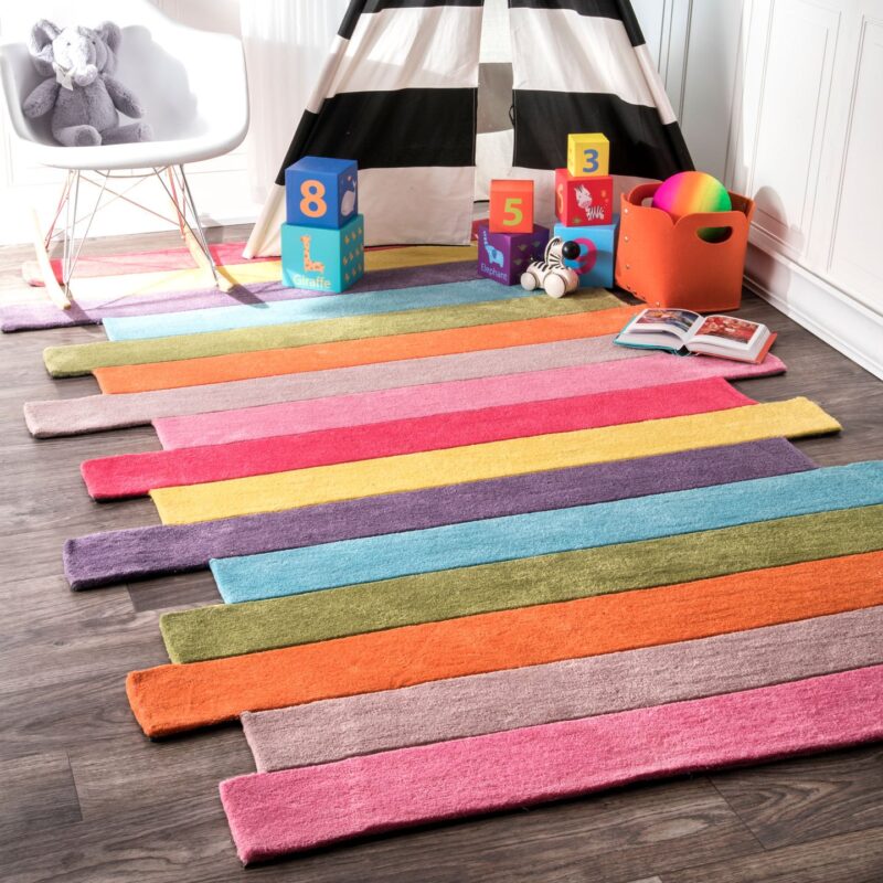 A rug is made up of different colored stripes. The edges are jagged.