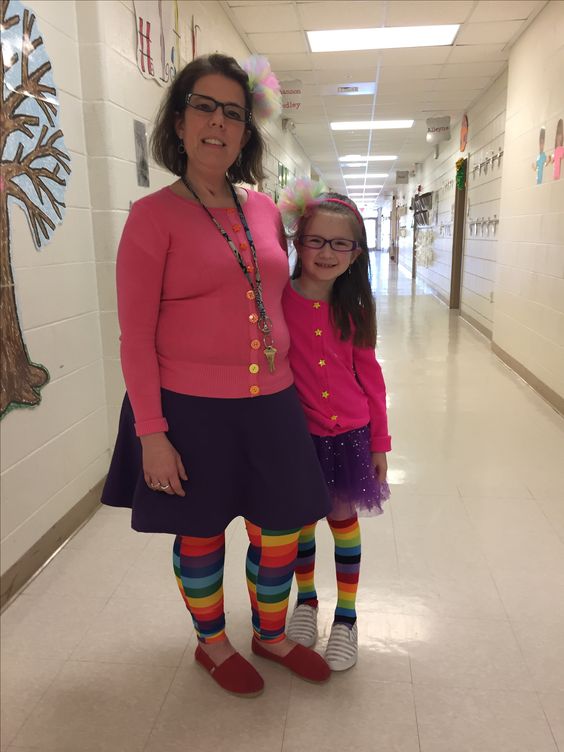 A teacher and a little girl are wearing matching outfits that include a hot pink cardigan, purple skirts, and rainbow knee highs.