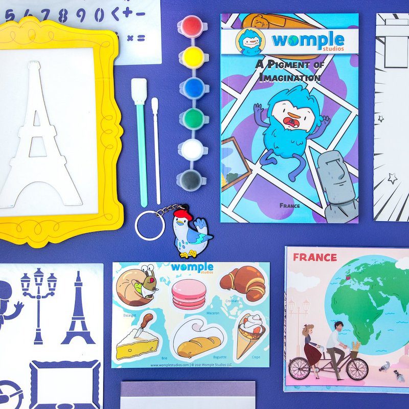 Collection of Womplebox educational subscription box items for France, including info booklet and arts and crafts projects