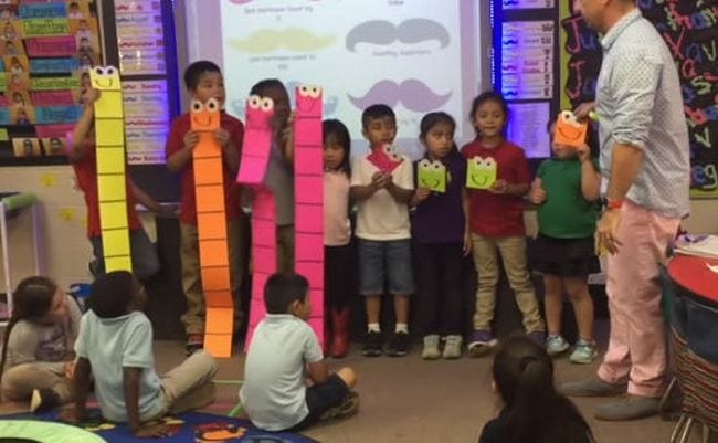Students holding giant DIY ones and tens blocks