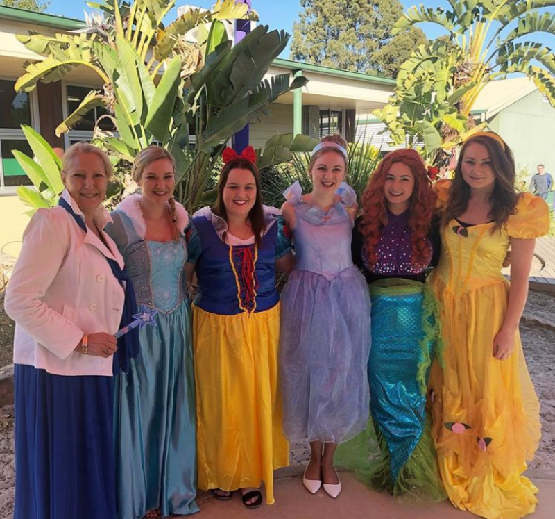 Six women are dressed up as different Disney princesses.
