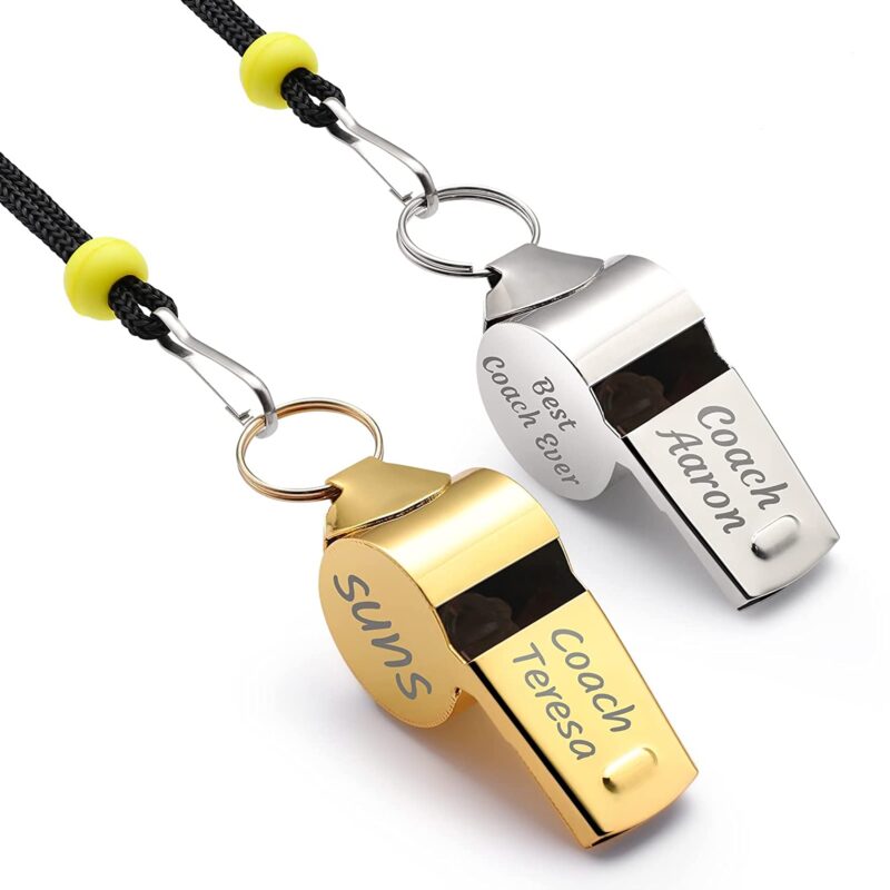 Two whistles a gold and a silver one have personalization engraved on them.