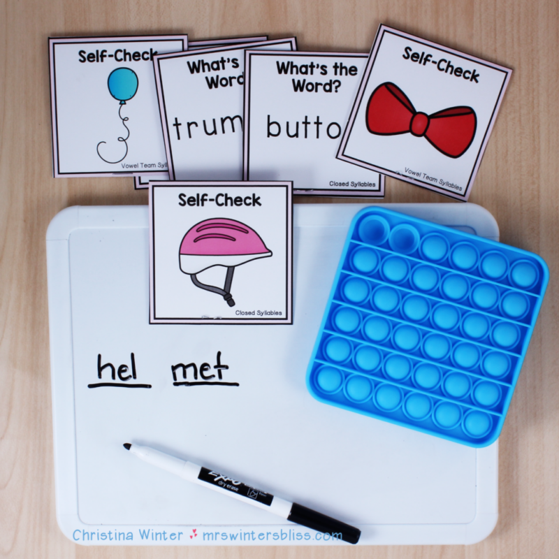 blue bubble popper with a whiteboard and black dry-erase marker, word cards, and the word 