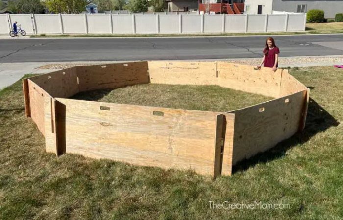 Woman standing by a gaga ball pit made of plywood sheets
