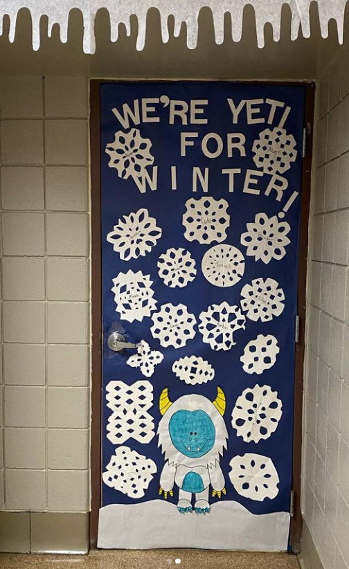 A classroom door says we're yeti for winter and it has a yeti and snowflakes on it. 