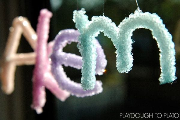 Crystalized pipe cleaner letters against a black background