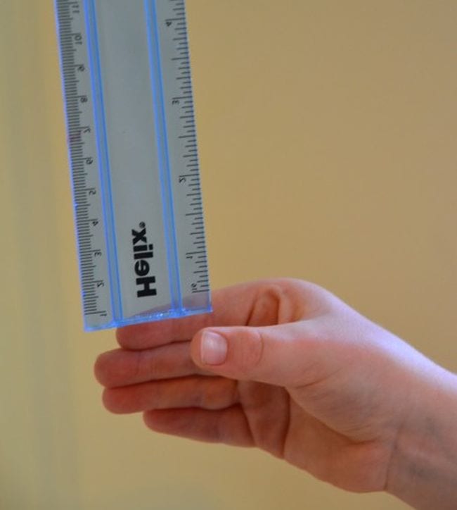 Blue ruler dropping into student's hand