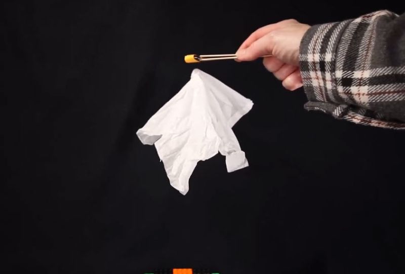 Child using a magnet to make a tissue paper 