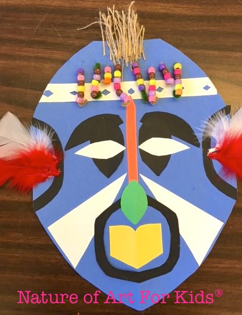 An African mask is constructed from paper, beads, and other mixed media.