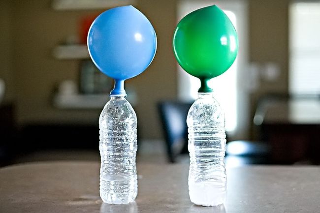 Two water bottles with inflated balloons attached to the openings