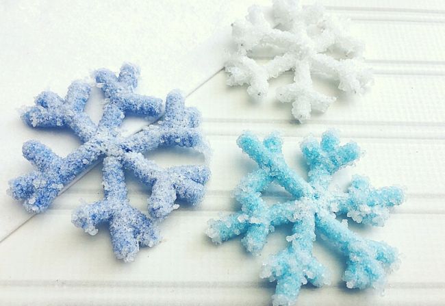 Three snowflakes made from pipe cleaners and crystallized