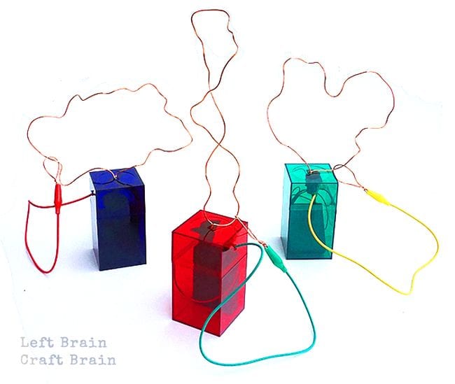Three colorful plastic boxes with wires and electrical wires sticking out of them