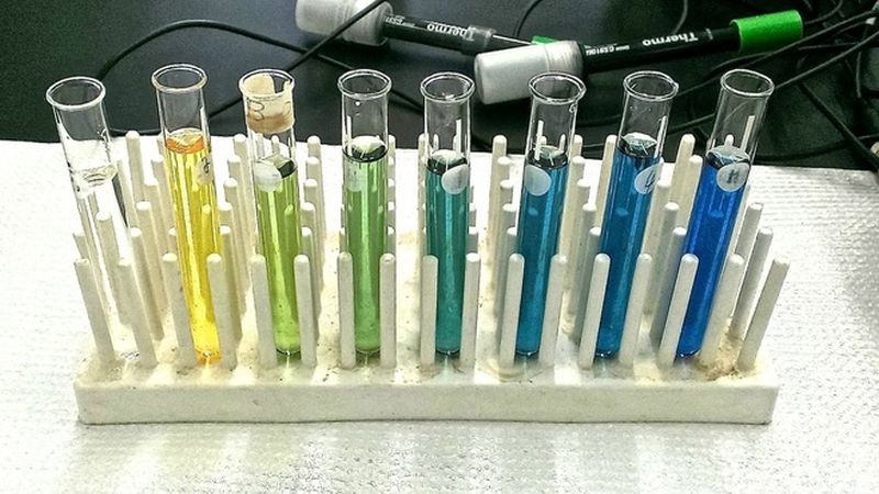 Series of test tubes filled with liquid ranging from yellow to green to blue