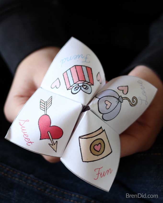 A child's hands hold a valentine themed cootie catcher