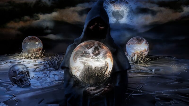 A hooded figure folding out a crystal ball with a spooky image in it