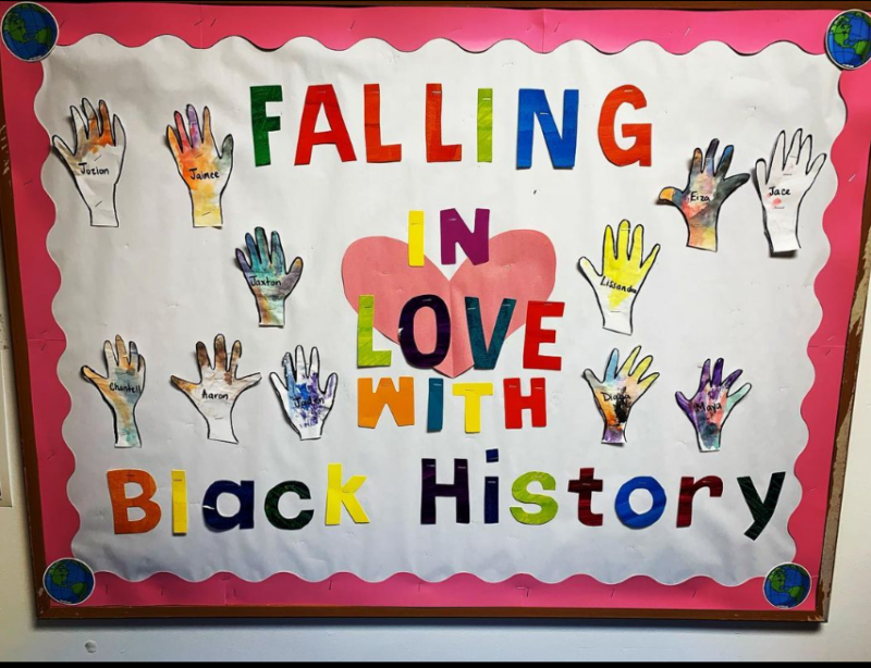 A bulletin board says Falling in Love with Black History. It has hands with names on it and a big heart.