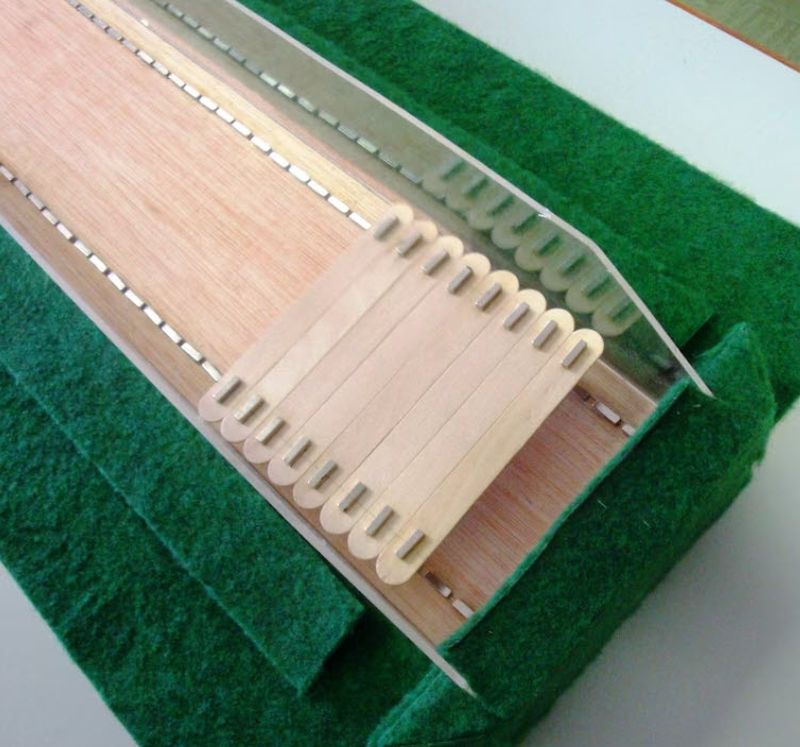Maglev model train built from magnets and wood craft sticks on green felt