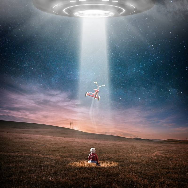 Small child sitting in a field watching a flying saucer beam up its tricycle (Middle School Picture Writing Prompts)