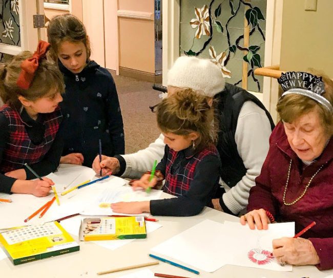 Children and senior citizens working on an art project together