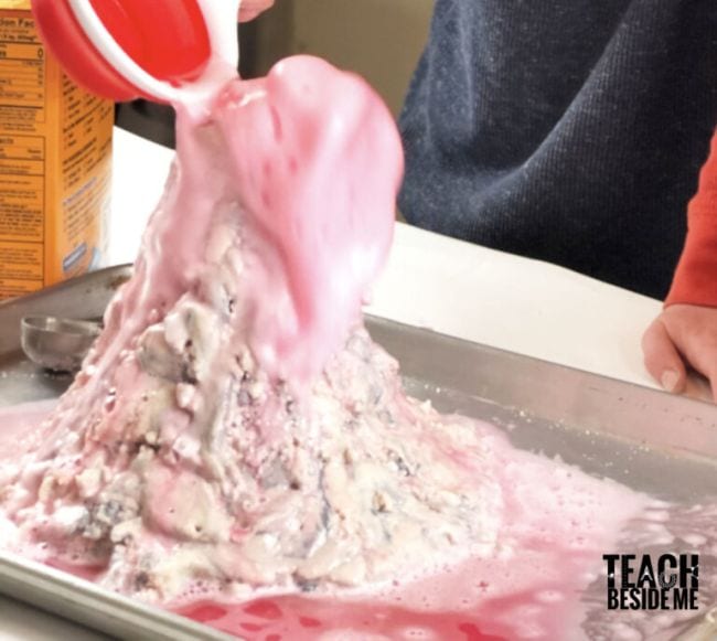 Student pouring vinegar into a salt dough volcano 