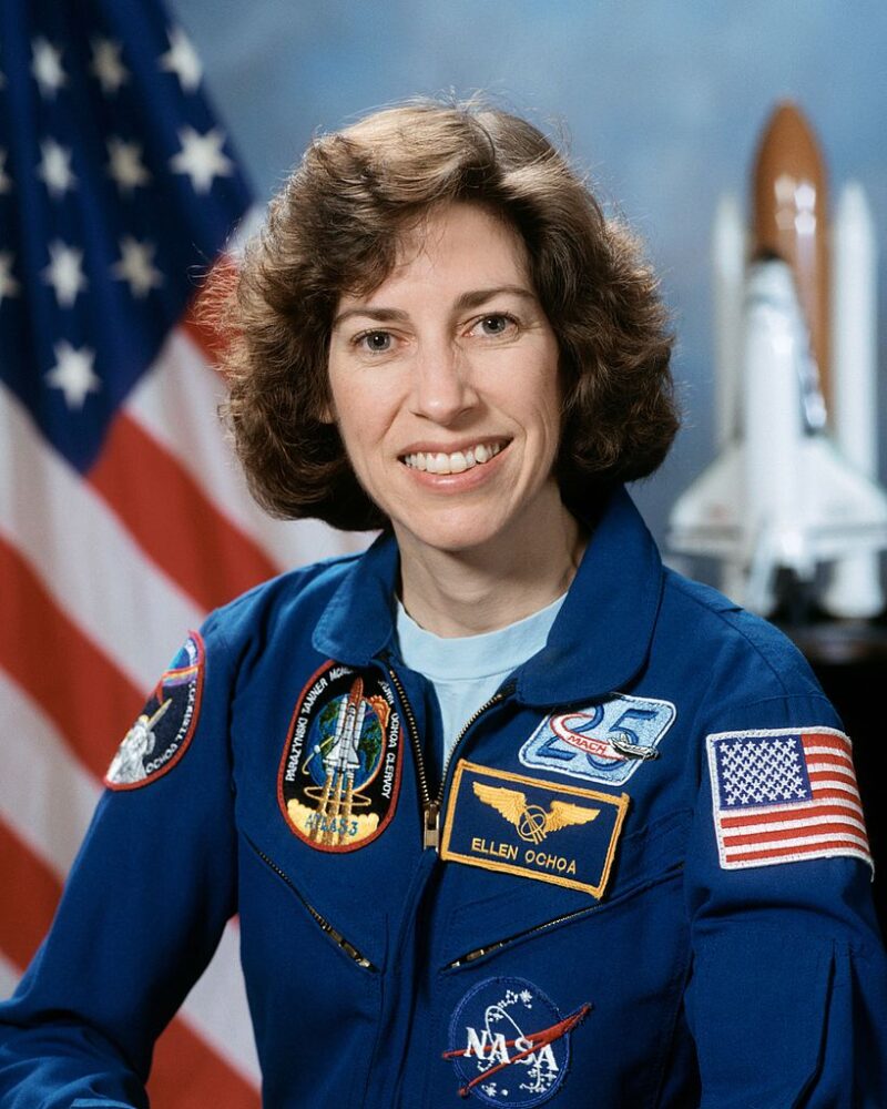 Portrait of NASA Astronaut Ellen Ochoa wearing a blue flight suit.