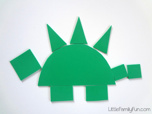 A green dinosaur is constructed from various shapes. 