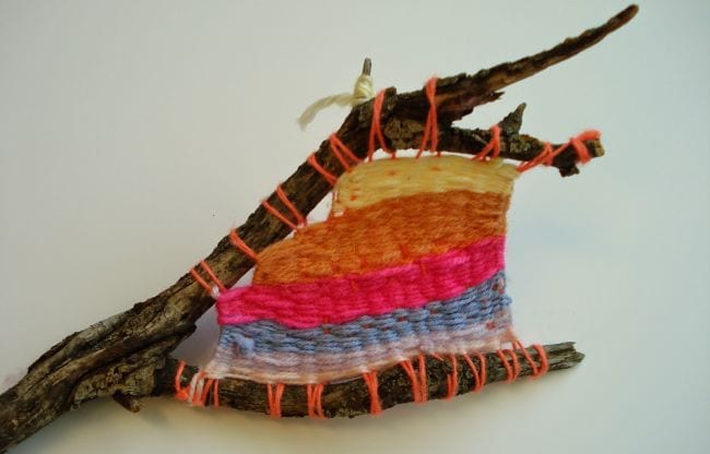 Stick sculpture with yarn woven between the branches