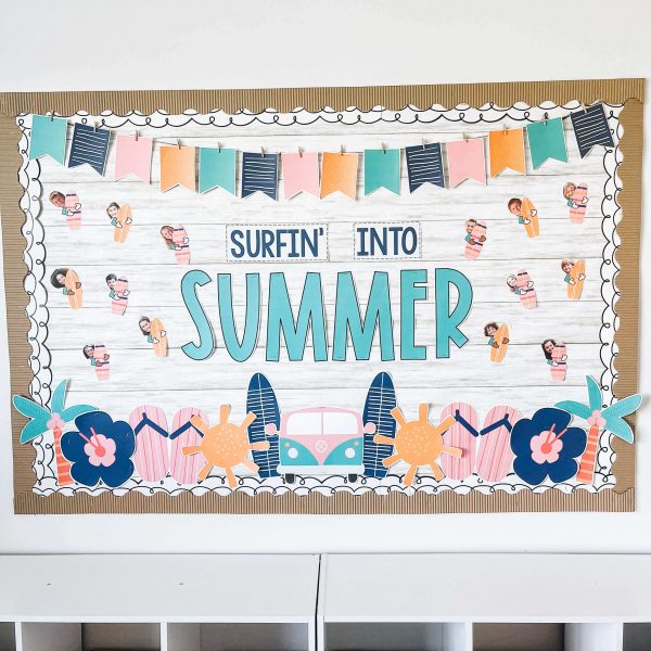 A bulletin board says Surfin into summer. There are photos of students holding small surfboards all over (summer bulletin board ideas)