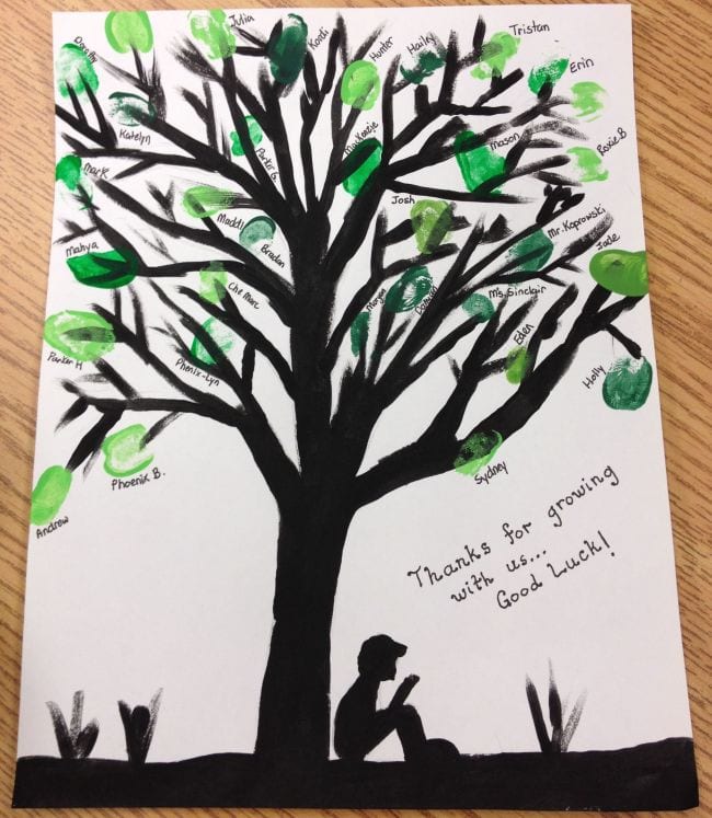 A silhouette of a boy sitting under a tree made from fingerprints