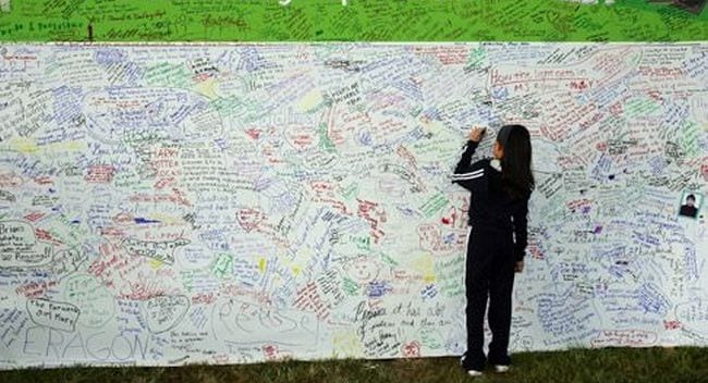A student adding her thoughts to a graffiti wall as an example of end of year activities