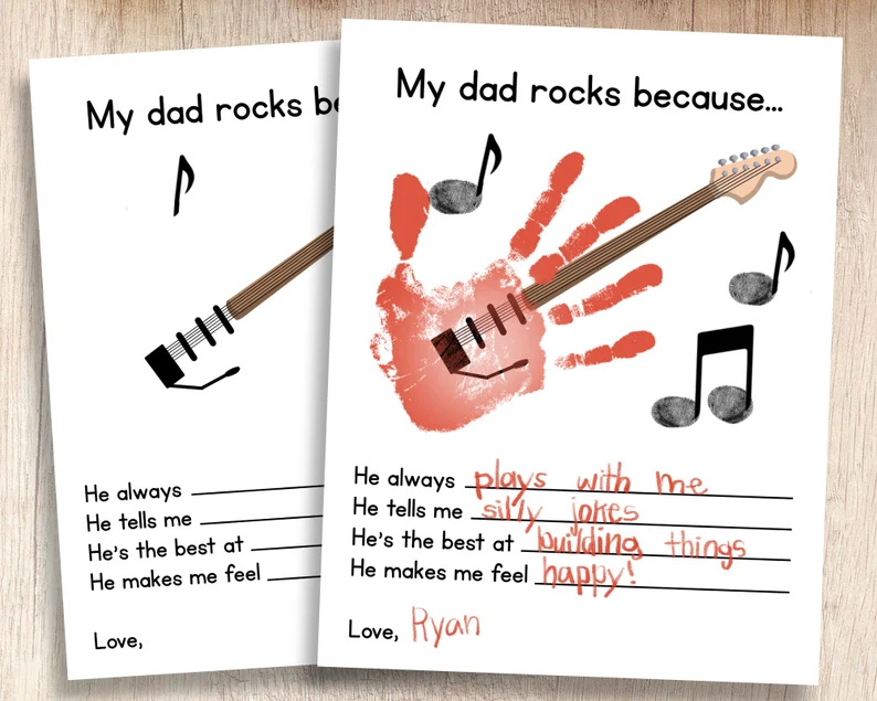 Two pieces of paper are shown. One has a handprint turned into a guitar on it. It says My Dad rocks because.