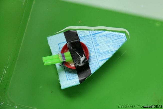 Small simple boat made of a piece of styrofoam and a plastic straw
