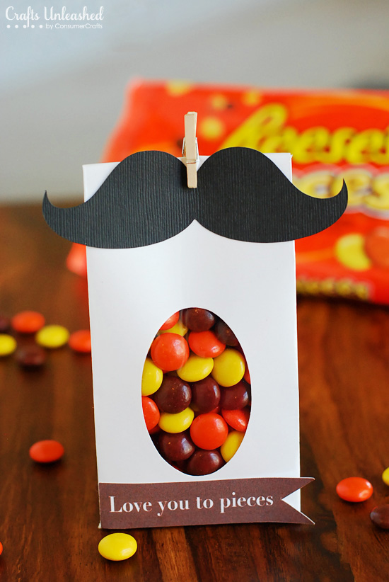 A white bag is filled with candy and has a black moustache on the top.