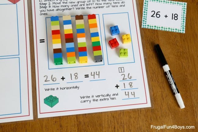 LEGO bricks laid out on a worksheet, used to demonstrate addition with regrouping