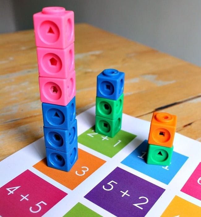 Math links cubes stacked on top of a printable worksheet of simple addition equations
