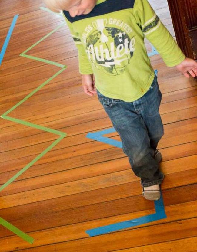 Toddler walking along a masking tape line on a floor