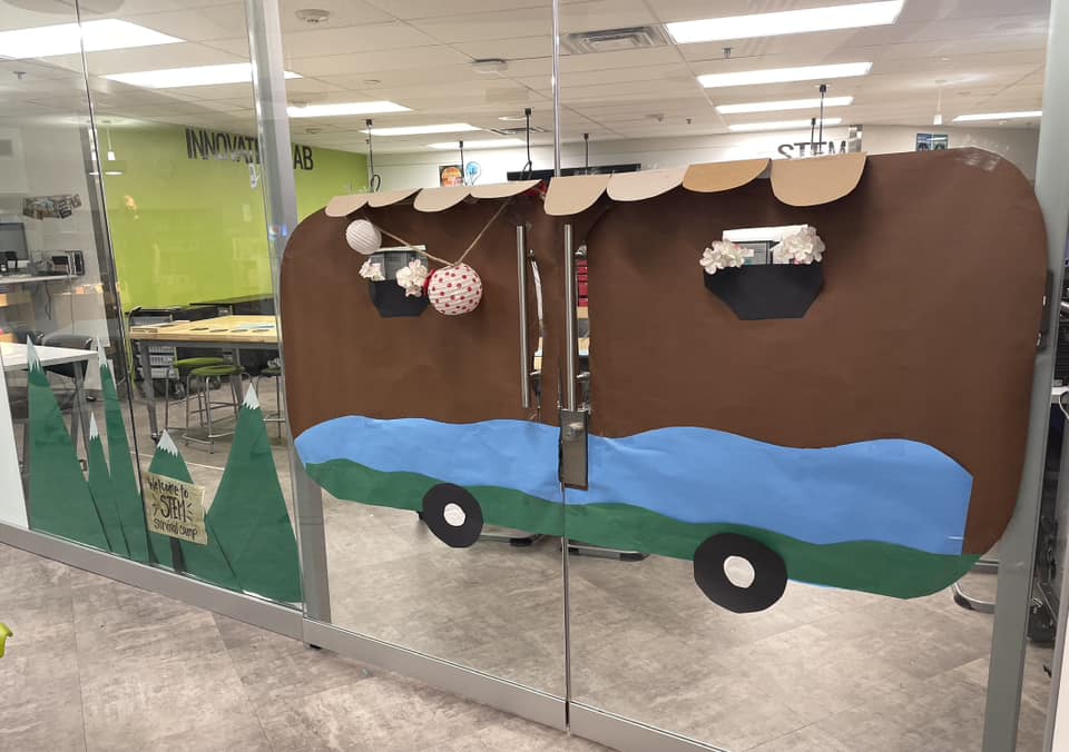 Classroom doors are decorated to look like a brown camper van.