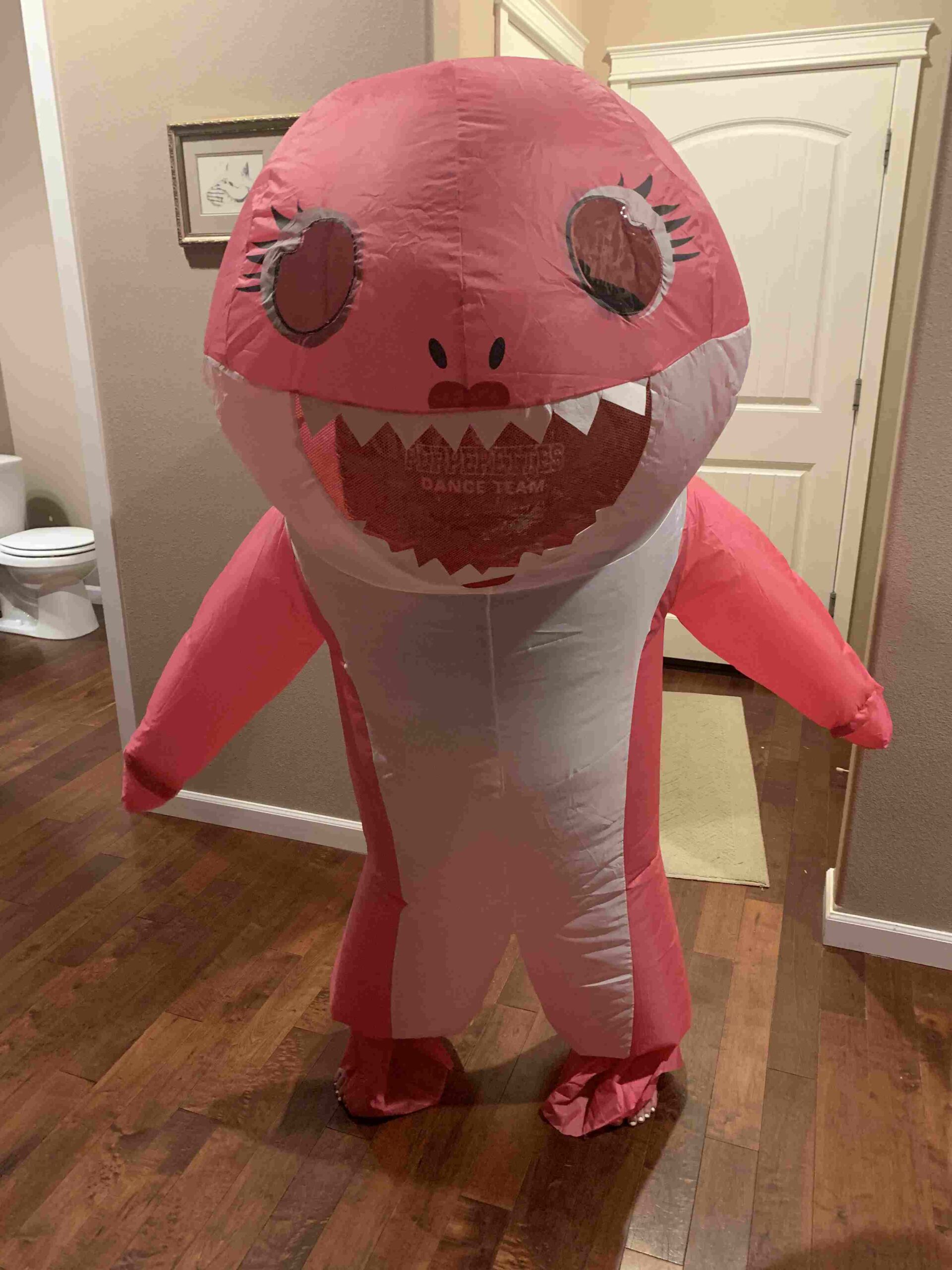 Teacher wearing a large inflatable pink shark costume