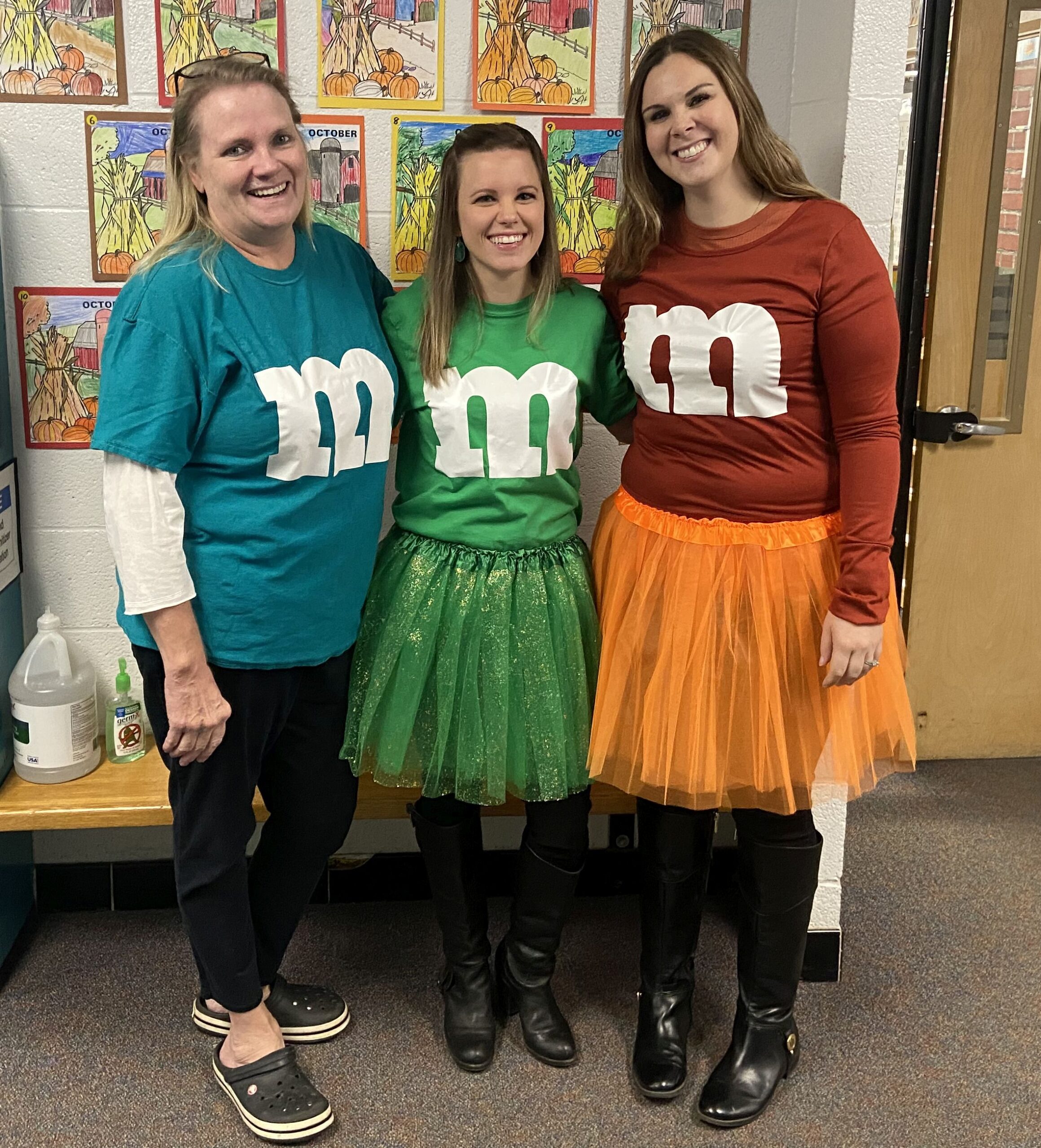 Teachers wearing colorful t-shirts with the M&M logo on them