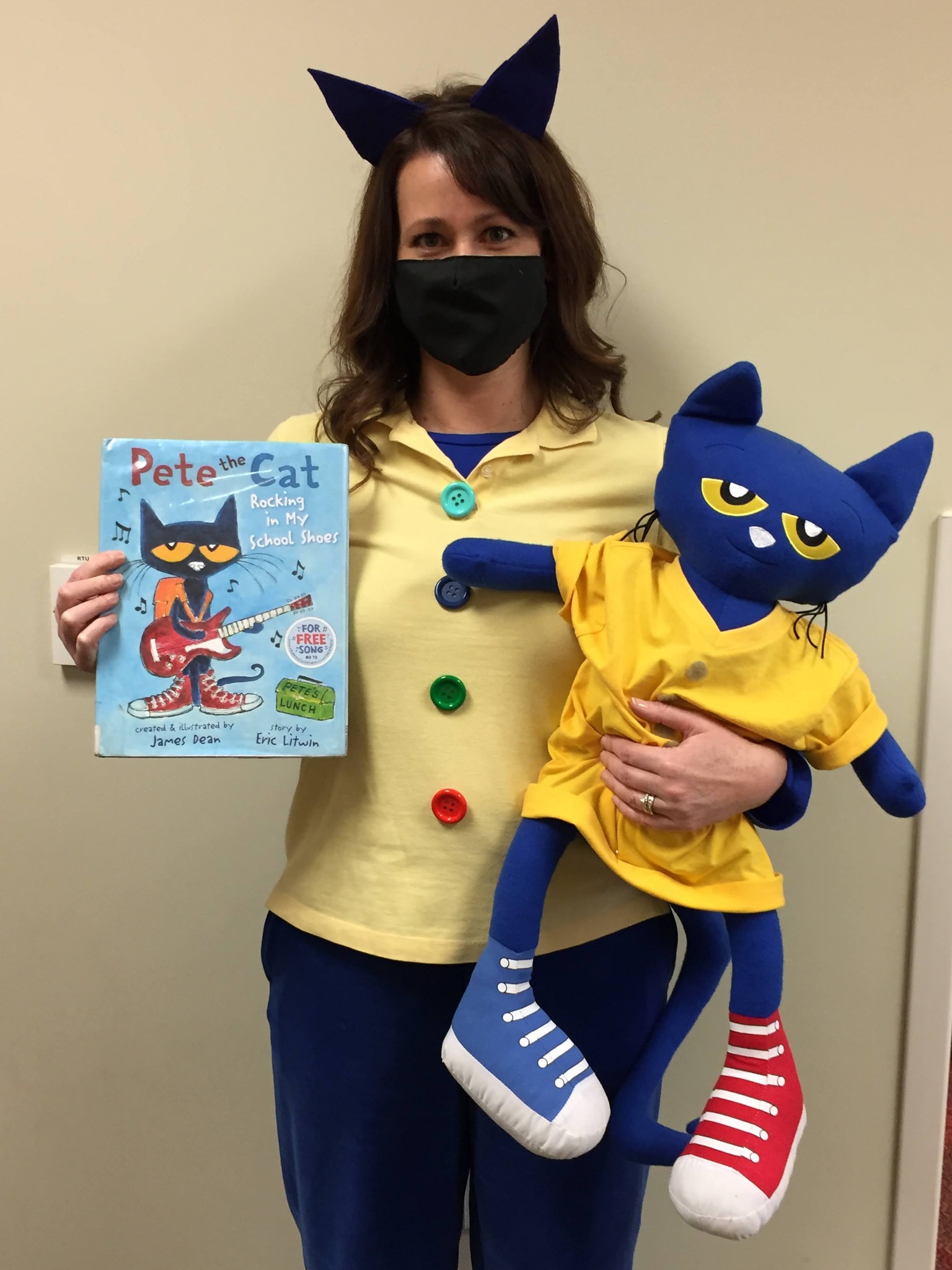 Librarian dressed as Pete the Cat, holding a stuffed Pete and a copy of a Pete the Cat book