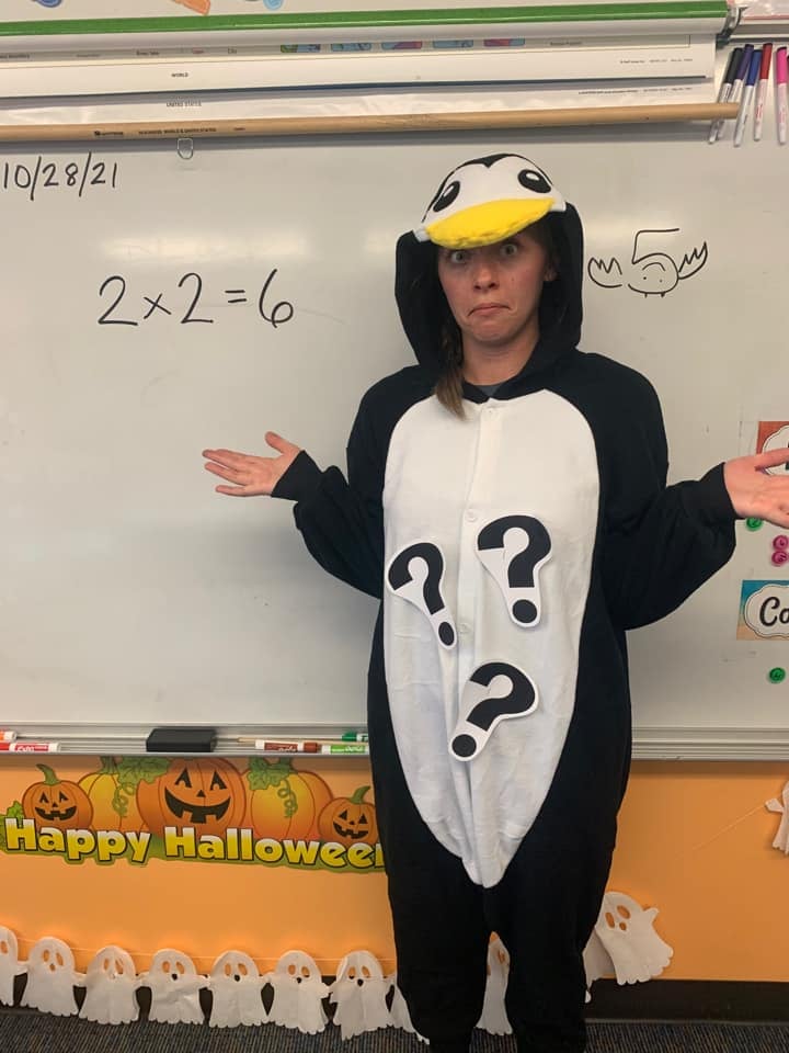 Teacher wearing a penguin costume with question marks attached