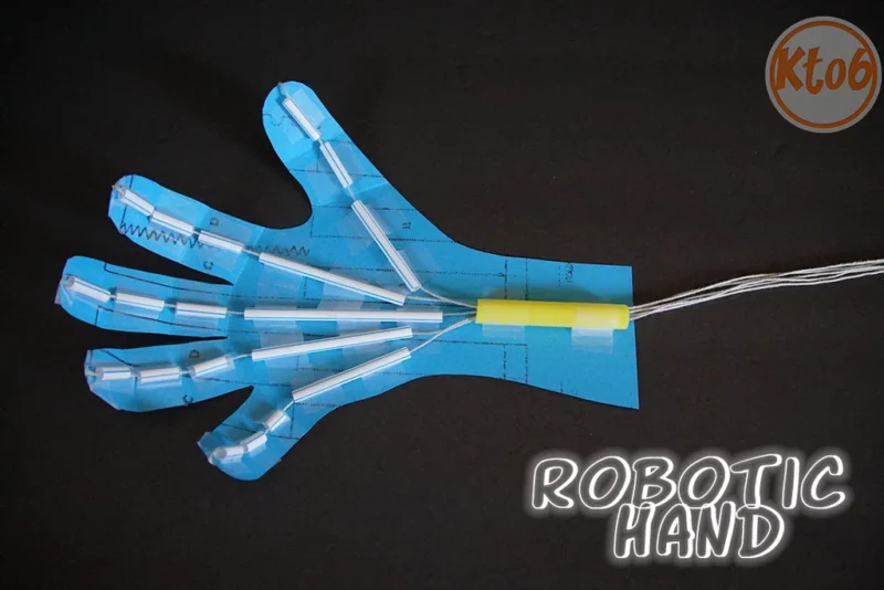 A robotic hand made from blue construction paper, segments of a drinking straw and string