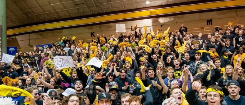 Student section cheering in an auditorium