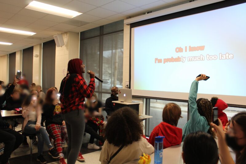 A student sings karaoke from words on a screen